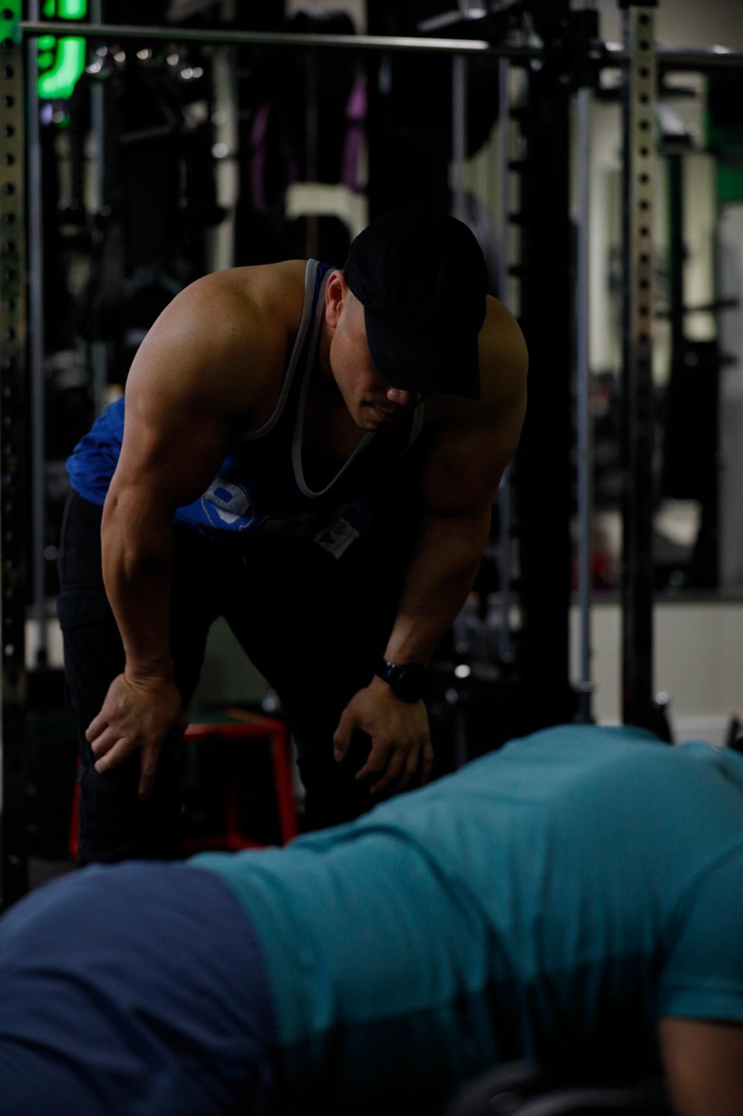 Elwil watching a client's form closely during a set