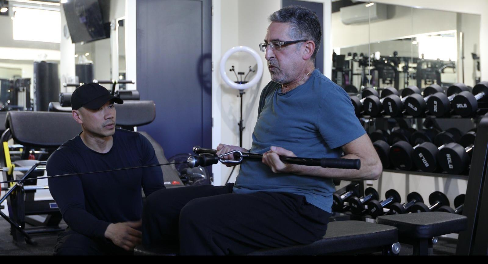 Elwil coaching an older client through a seated cable row