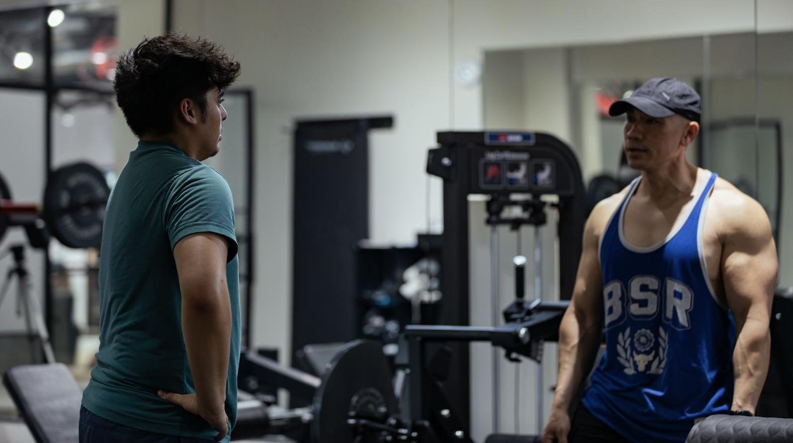 Elwil talking through a session plan with a client on the gym floor